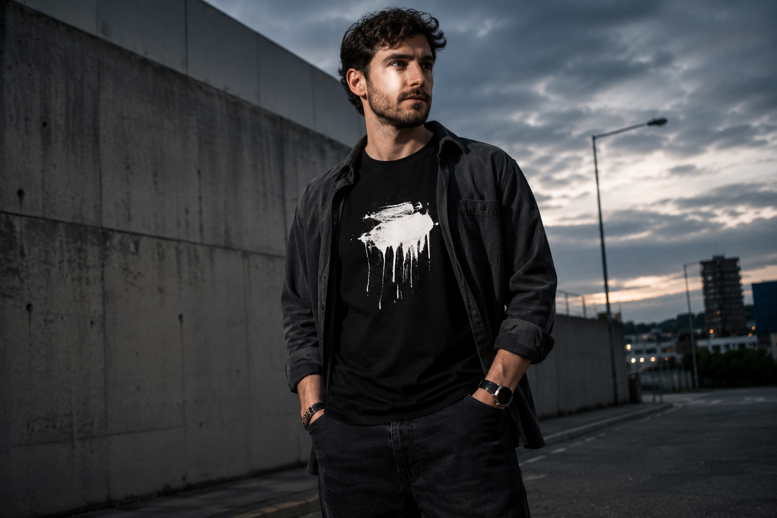 Man styling a black statement T-shirt with a charcoal overshirt and dark jeans